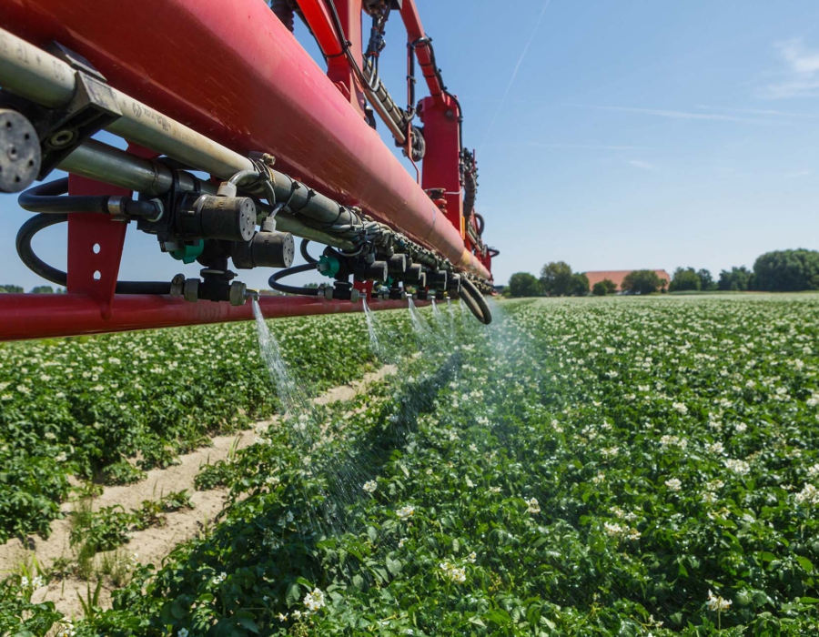 An Agrifac sprayer efficiently spraying liquid across a lush green field, enhancing crop growth.