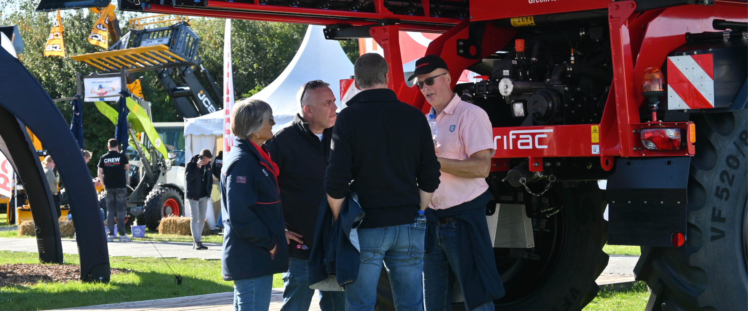 A sales person representing Agrifac at an event and talking to potential customers.