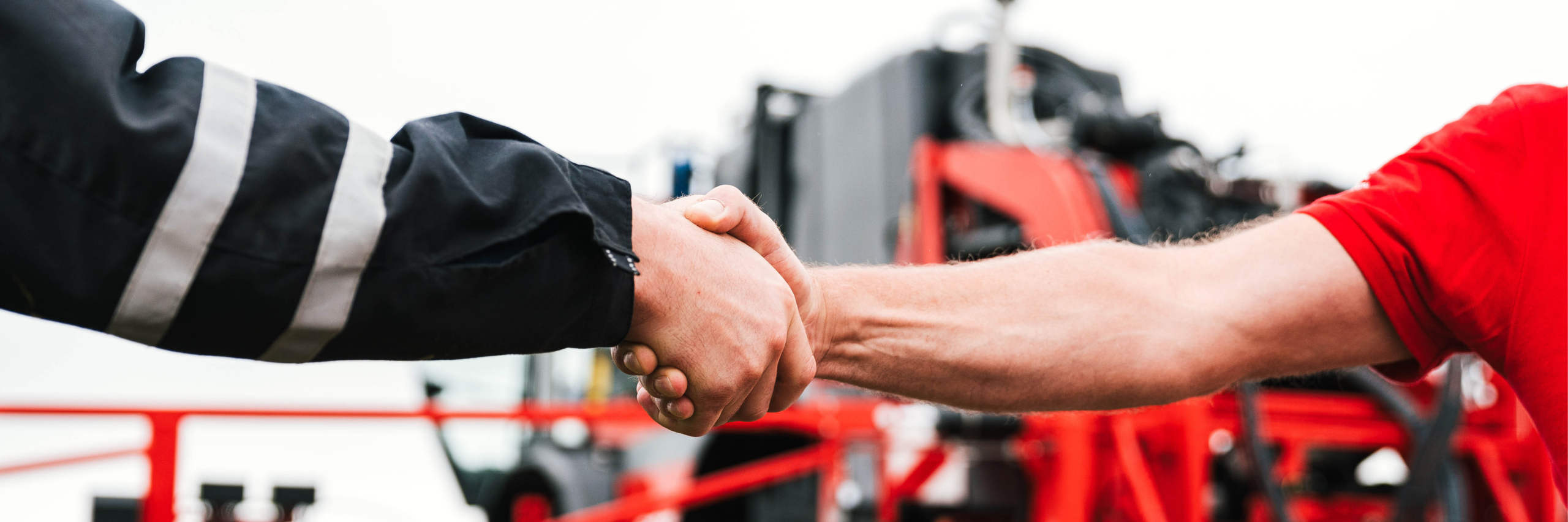 A man and another individual engaging in a handshake, symbolizing agreement or partnership in a professional setting.