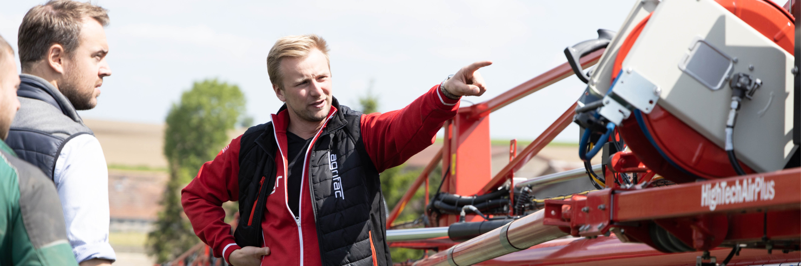 A sales representative of Agrifac talking to customers in the field.