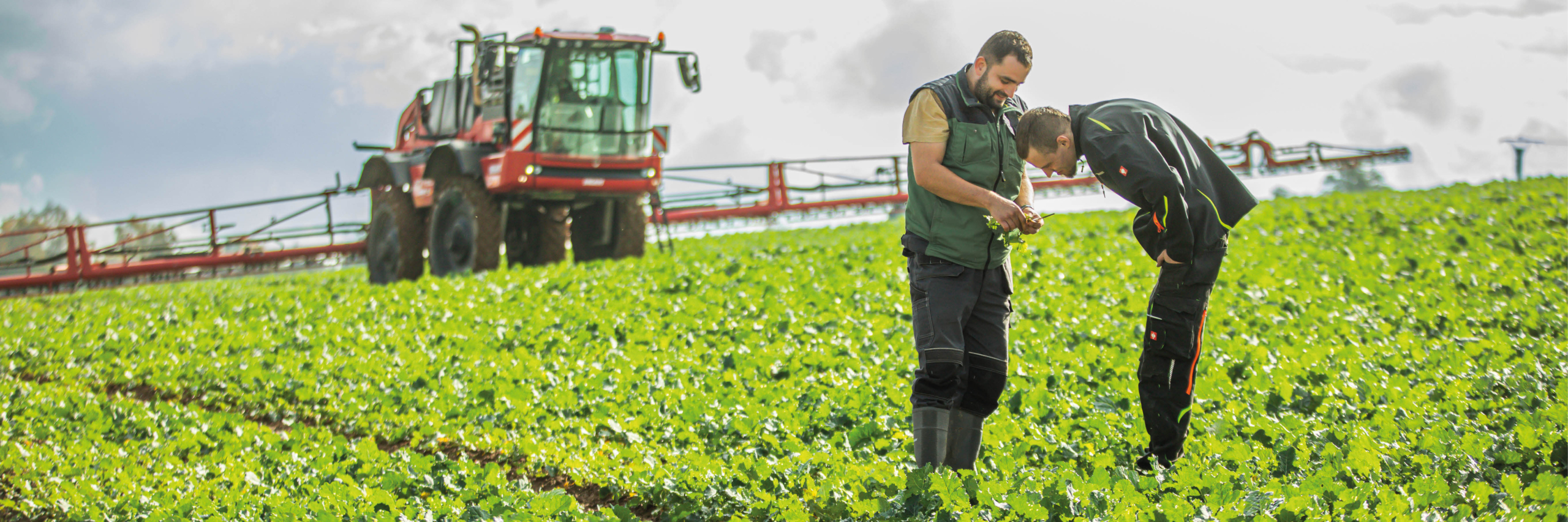 In a field, two men use an Agrifac sprayer to spray crops, promoting agricultural productivity and crop health.