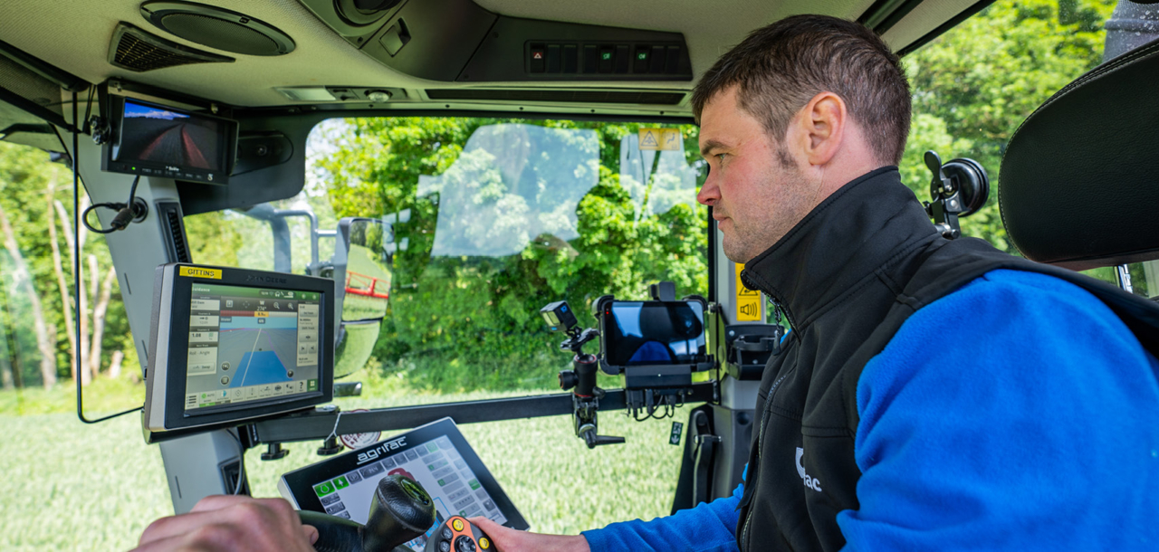 A person sitting in the cab of an Agrifac Condor.