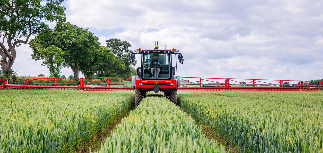 View of an Agrifac Vanguard sprayer driving in a vast agricultural field, showcasing modern farming techniques.