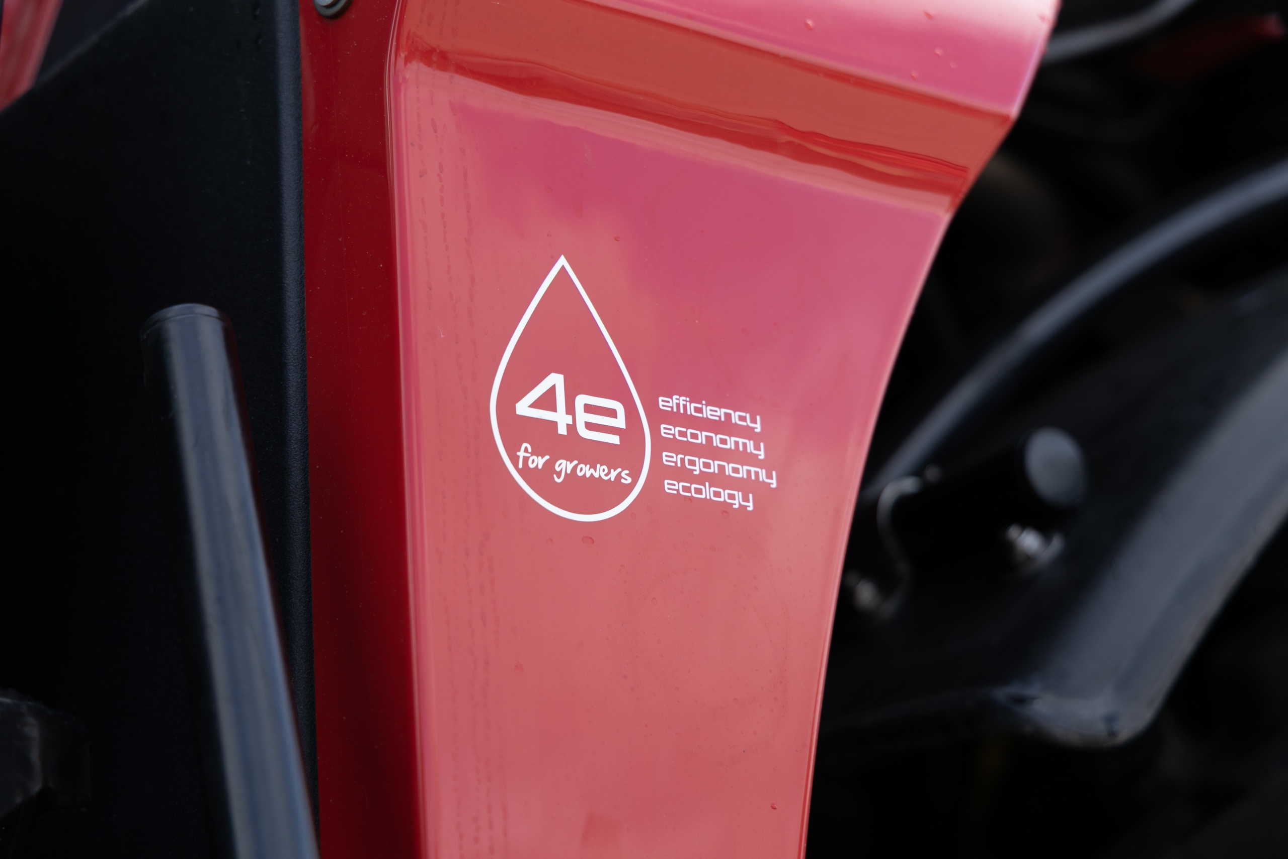 Close up of a red Agrifac sprayer with a prominent slogan sticker on the body.