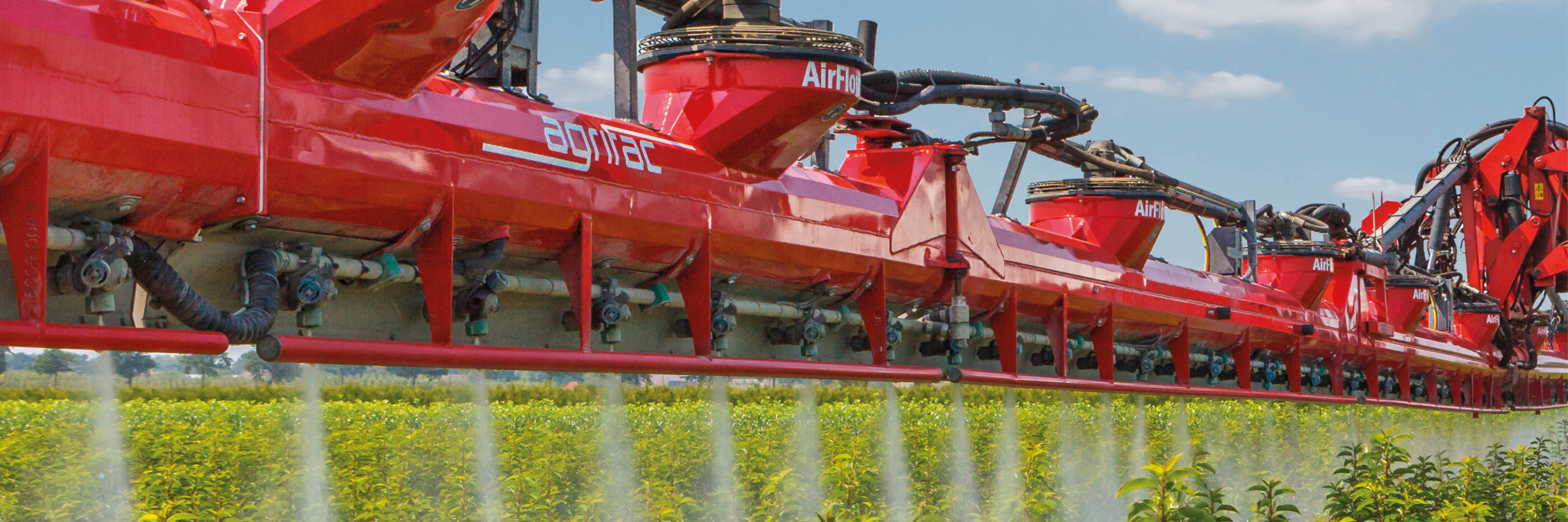 An Agrifac sprayer with AirFlow boom, spraying a green field, showcasing agricultural action and drift reduction.