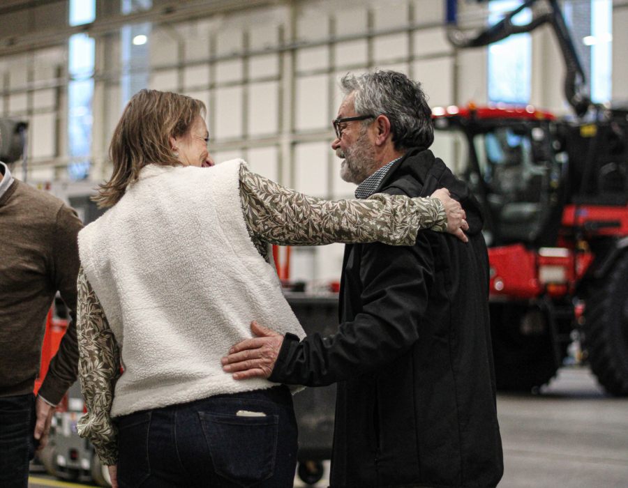 Employees greeting each other inside a factory environment.