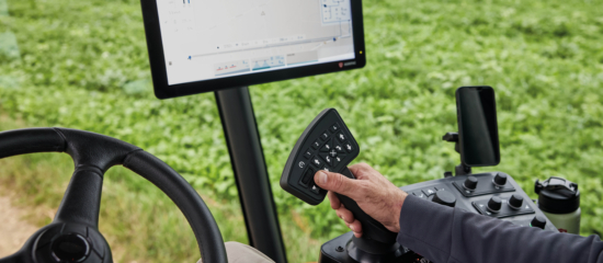 A close up view of the inside of the Agrifac cab with different buttons and a screen.