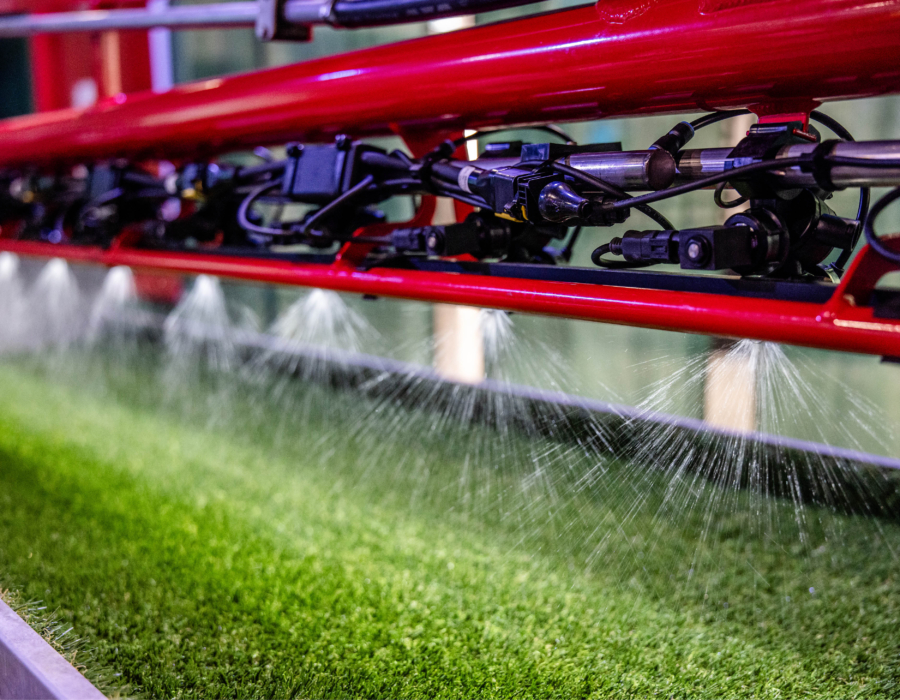 Agricultural spray boom demo model actively spraying.